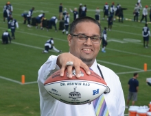 Ashwin Rao ’99 holding a football while wearing his Super Bowl ring.